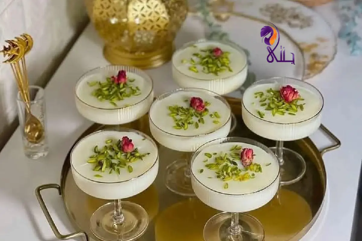 حلى السميد اللذيذة بالحليب تقدم في كاسات زجاجية مع القشطة والفراولة والفستق